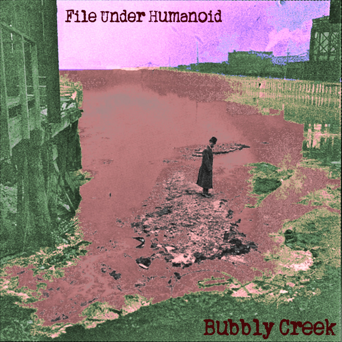 Hand-tinted archival photograph of a man in a long coat standing on the crusted surface of Bubbly Creek, buildings and rail structures at the edges.