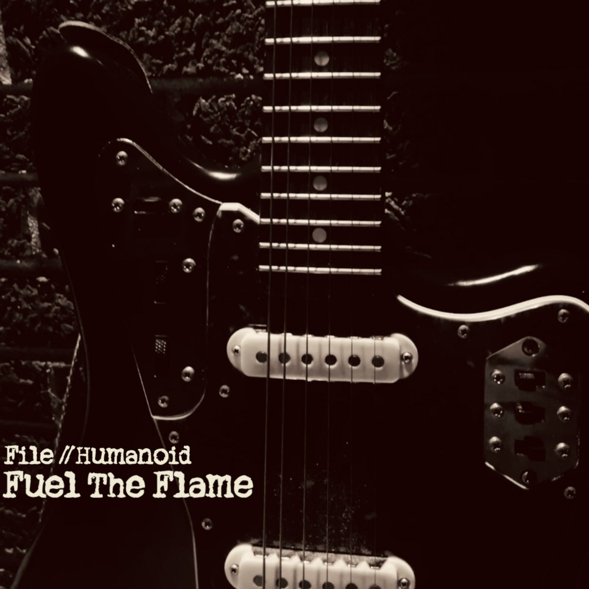 A Fender Jaguar alone against a brick wall, sepia-warm light, no player visible.